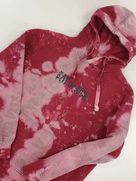 Roter Kapuzenpullover mit Batikmuster in helleren Farbtönen und schwarzem Schriftzug auf der Brust Red hoodie with lighter tie-dye pattern and black text on the chest 