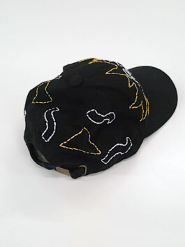 Schwarze Baseballkappe mit gelben und weißen abstrakten Stickmustern auf der Oberseite Black baseball cap with yellow and white abstract embroidered patterns on the top 