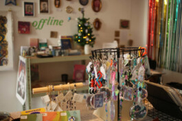 Rotating stand with various keychains in a shop with a Christmas tree and 'offline' sign on the wall Drehständer mit verschiedenen Schlüsselanhängern in einem Laden mit Weihnachtsbaum und 'offline'-Schriftzug an der Wand 