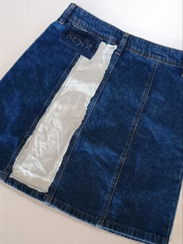 Jeansrock mit eingesetztem hellen Stoffstreifen und aufgenähtem rechteckigem Patch mit der Aufschrift 'RESIST'