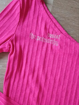 Rosa, geripptes, einarmiges Oberteil mit weißer Stickerei 'resist the patriarchy' am Ausschnitt