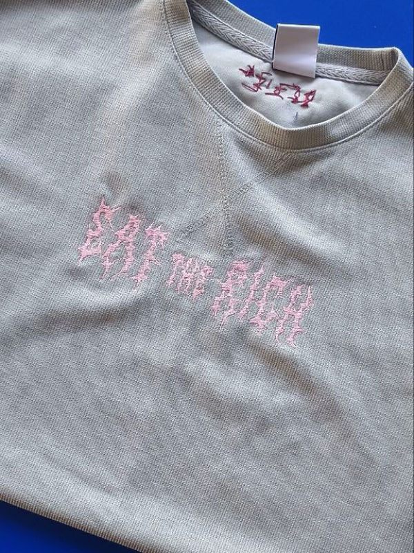 Hellgraues T-Shirt mit rosa gesticktem Schriftzug