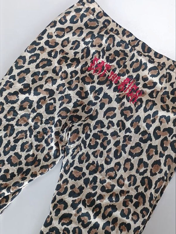 Hose mit Leopardenmuster und roter Schrift 'eat the rich' auf der Rückseite